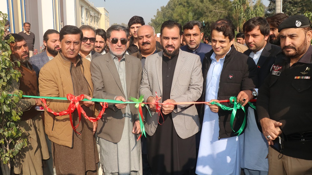 The Honorable Minister for Higher Education Mr. Meena Khan Afridi is cutting the blue ribbon at the eve of  Chrysanthemum exhibition.